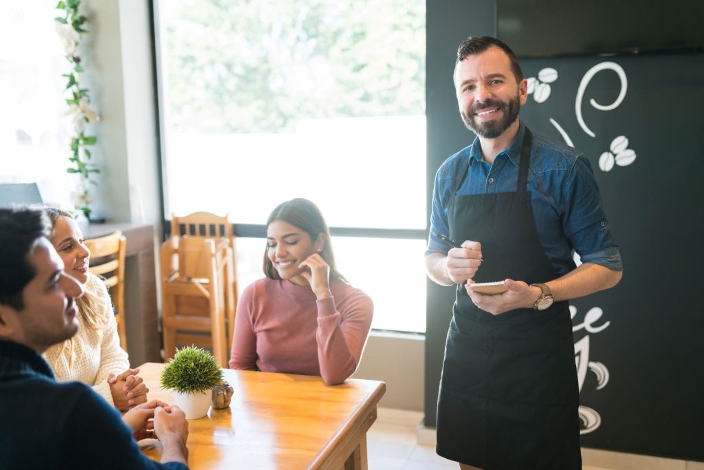 a waiter taking order and smiling