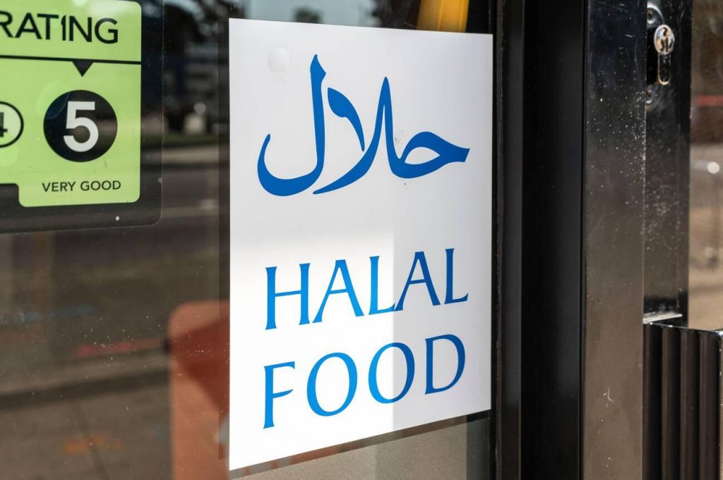 Halal Food sign written in Arabic and English displayed in the window of a restaurant