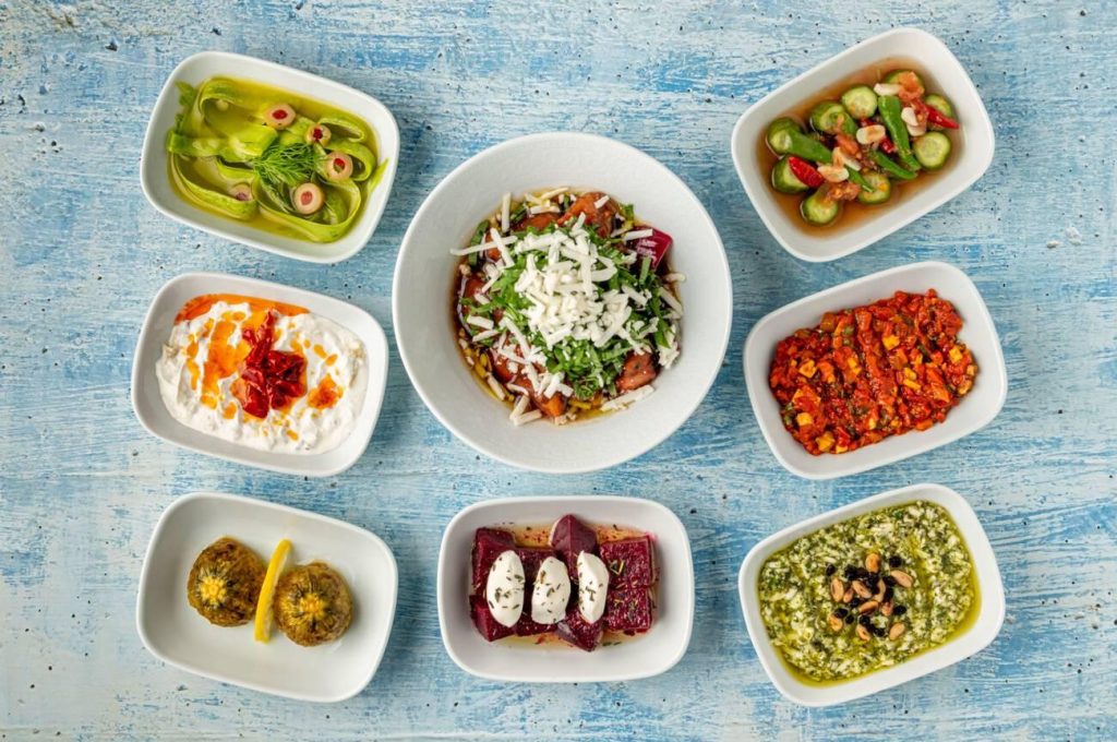 Different kinds of Turkish appetizers on white porcelain plates