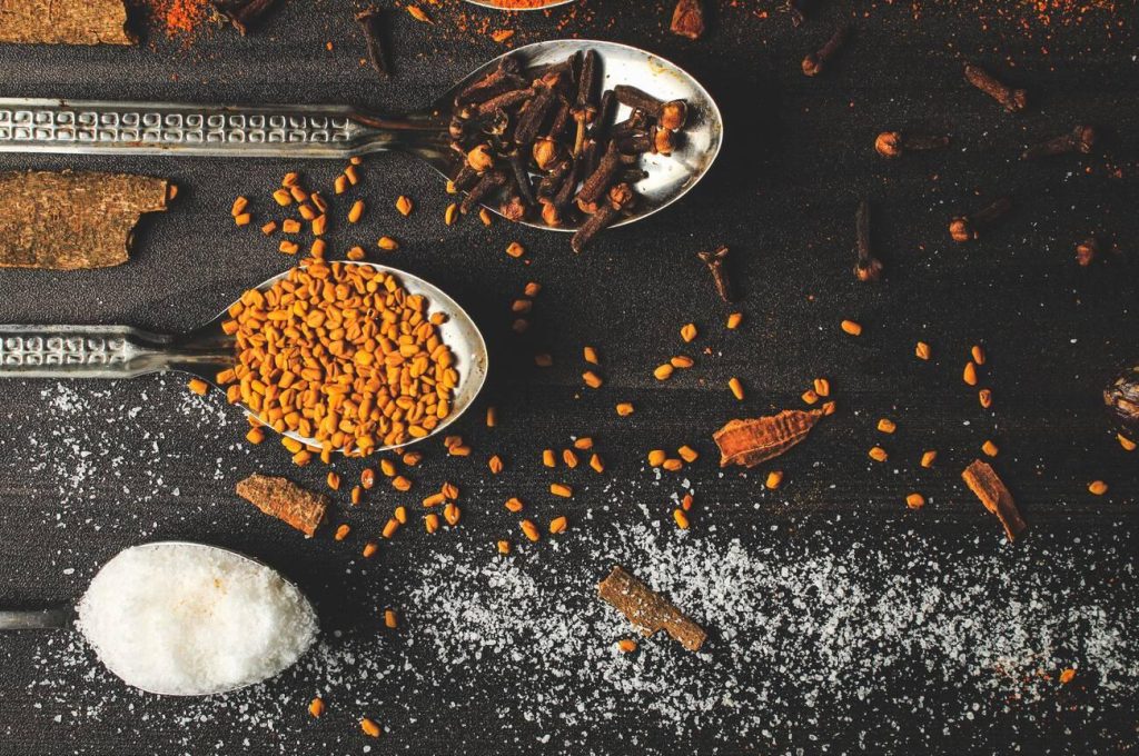 Traditional Pakistani spices including cloves, fenugreek seeds, and cinnamon used in authentic Pakistani cuisine