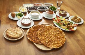 A diverse spread of Middle Eastern and Turkish Halal dishes, including Lahmacun, Kibbeh, and fresh salads, representing multicultural Halal flavors in Canada."