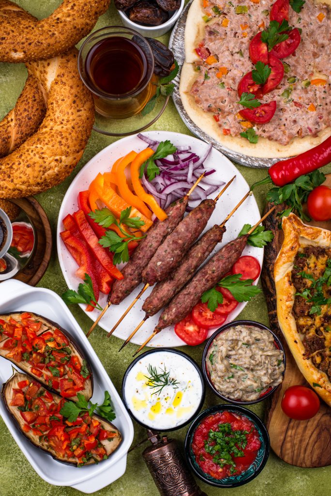 Traditional Adana kebab from Turkish cuisine, served with grilled vegetables and flatbread.