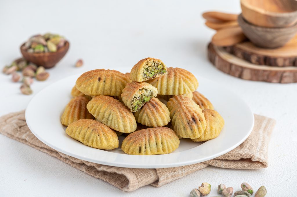 "A plate of traditional Arab Maamoul cookies stuffed with pistachios, a popular Eid al-Fitr dessert in Levant households."