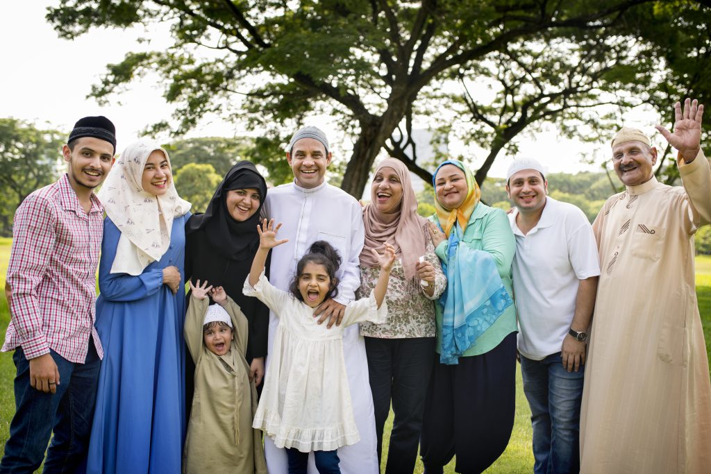 A diverse group of Muslims celebrating Eid al-Fitr in a public park