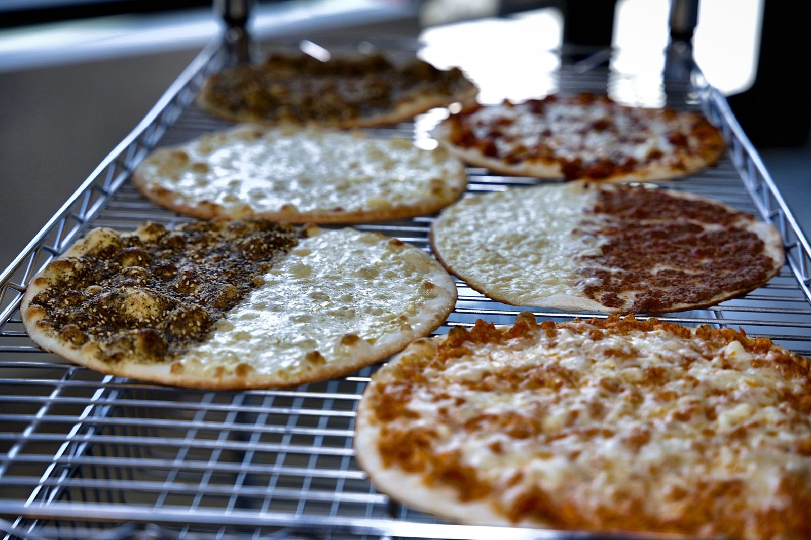 Rack of freshly baked Lebanese manaeesh at Sahtein Bakery