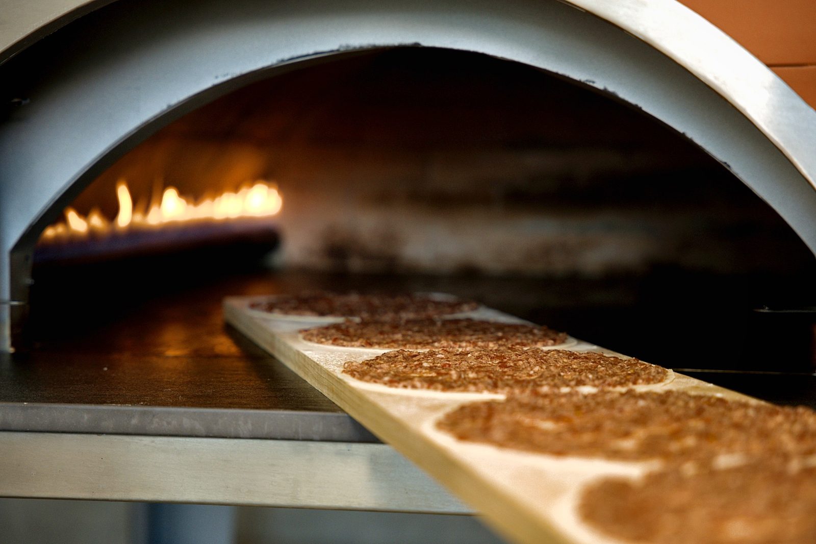 Fresh manaeesh baking beside the flame at Sahtein Bakery