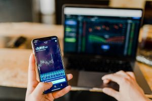 Person reviewing investments on a laptop and smartphone