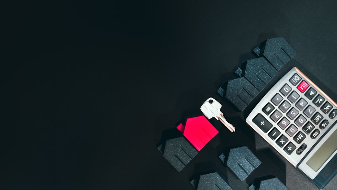 Calculator and house key representing home financing costs
