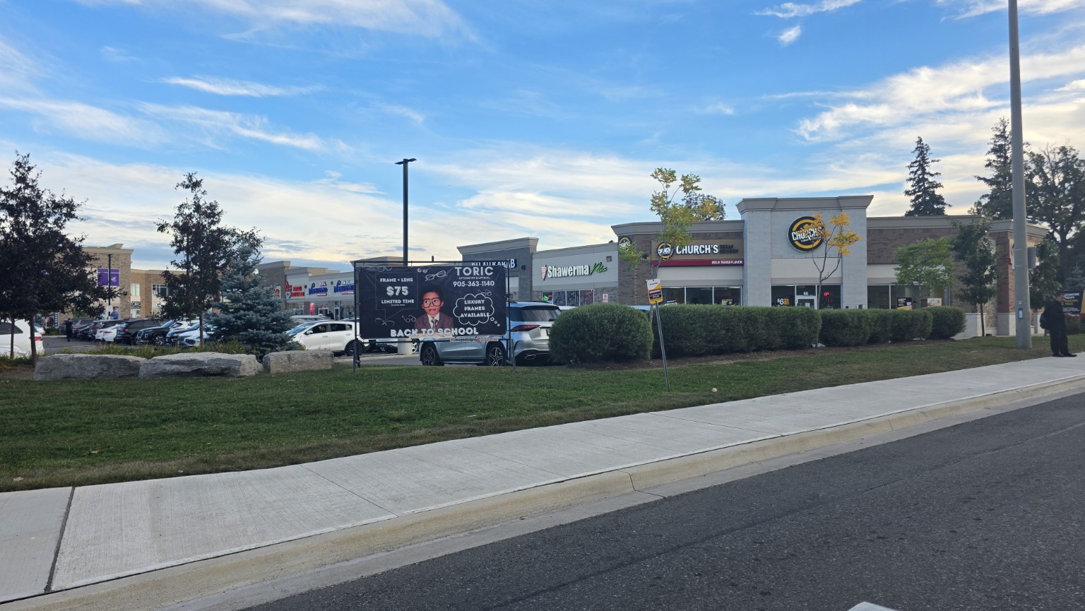 Ridgeway Plaza storefronts, parking and sidewalk in Mississauga